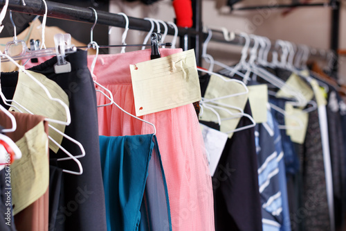 Clothes with tags on hangers in atelier
