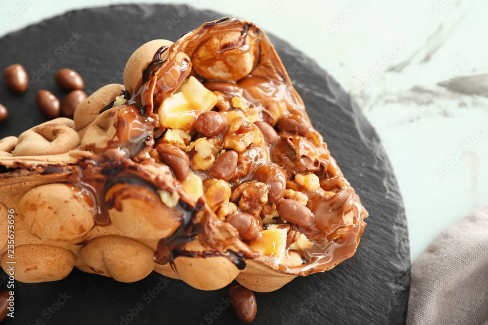 Delicious sweet bubble waffle on slate plate, closeup