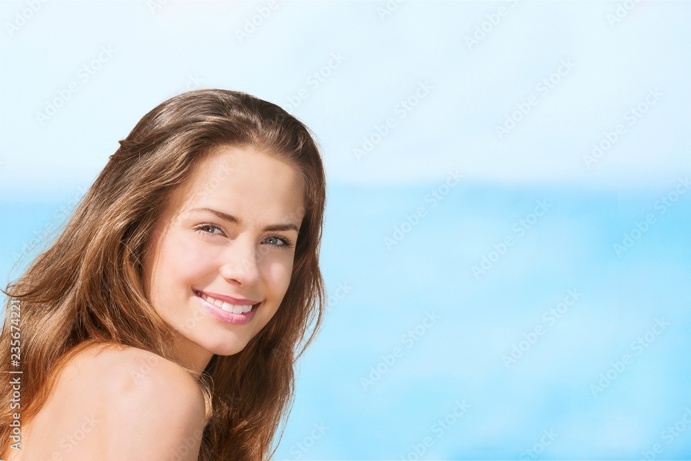 Young smiling woman on blurred ocean background