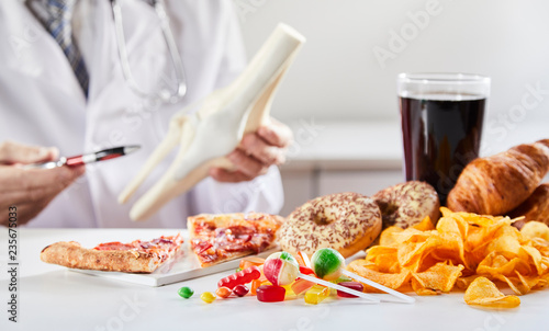 Fotografie Doctor showing link between bad food and disease