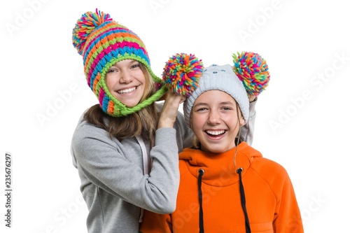 Close-up of winter portrait of attractive girl in knitted cap 12, 13 years old having fun, isolated on white background