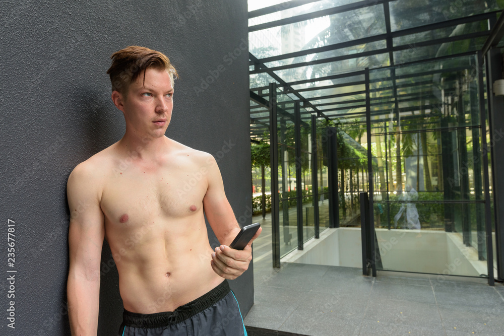 Obraz premium Young handsome man leaning against gray concrete wall and view o