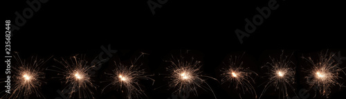 Wallpaper Mural A burning sparkler on a black background with copy space for you design, panorama, new year concept. Torontodigital.ca
