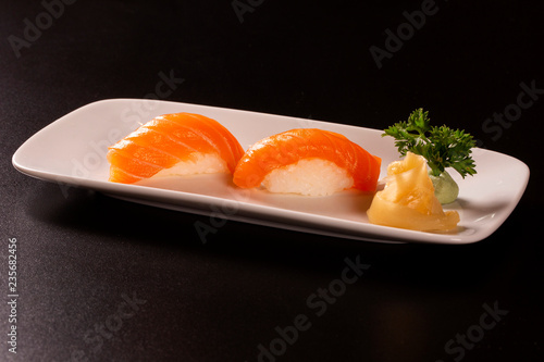 Sake - nigiri sushi with raw salmon on black background