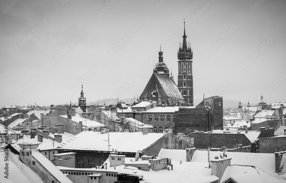 Krakow in Christmas time, aerial view on snowy roofs in central part of city. St. Mary's Basilica on Main Square. BW photo. Poland. Europe.