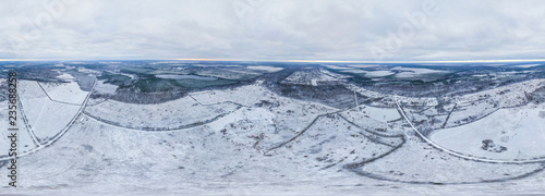 Aerial view of the lake, snow field and winter forest 