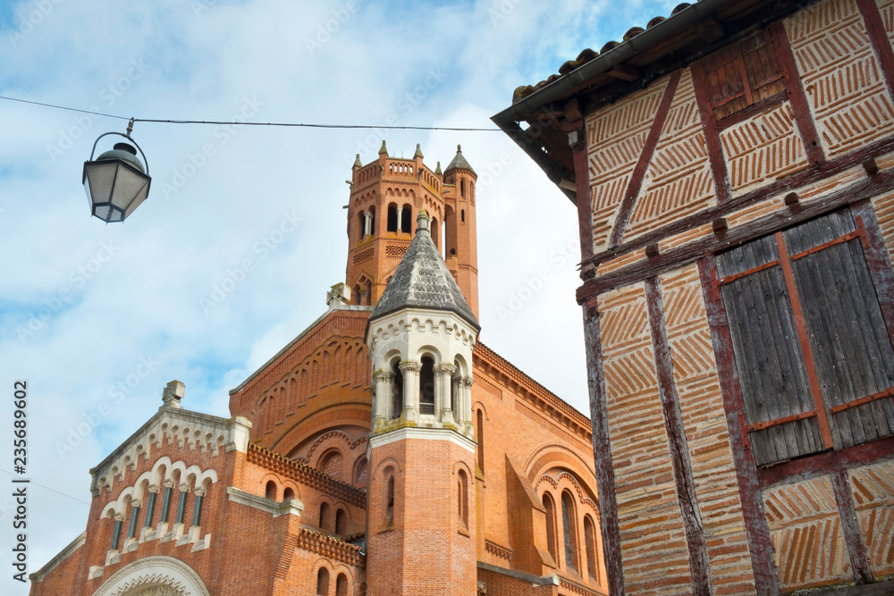The relatively recently constructed church (completed 1937) of Sainte-Catherine in Villeneuve-sur-Lot, Lot-et-Garonne, France contrasts with much older architecture around it.