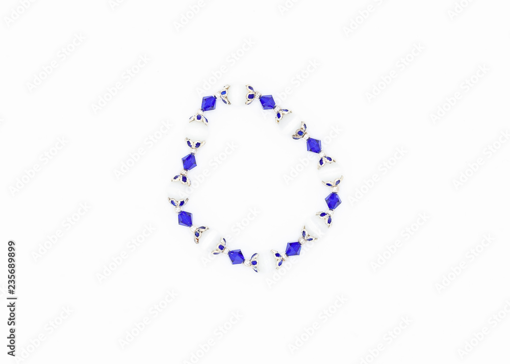 blue and white colored and variously sized beads bracelet on white background