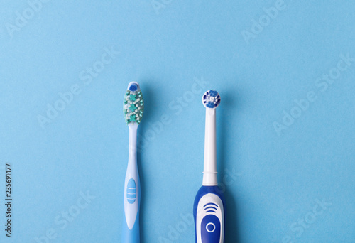 electric and classic toothbrush on a blue background photo