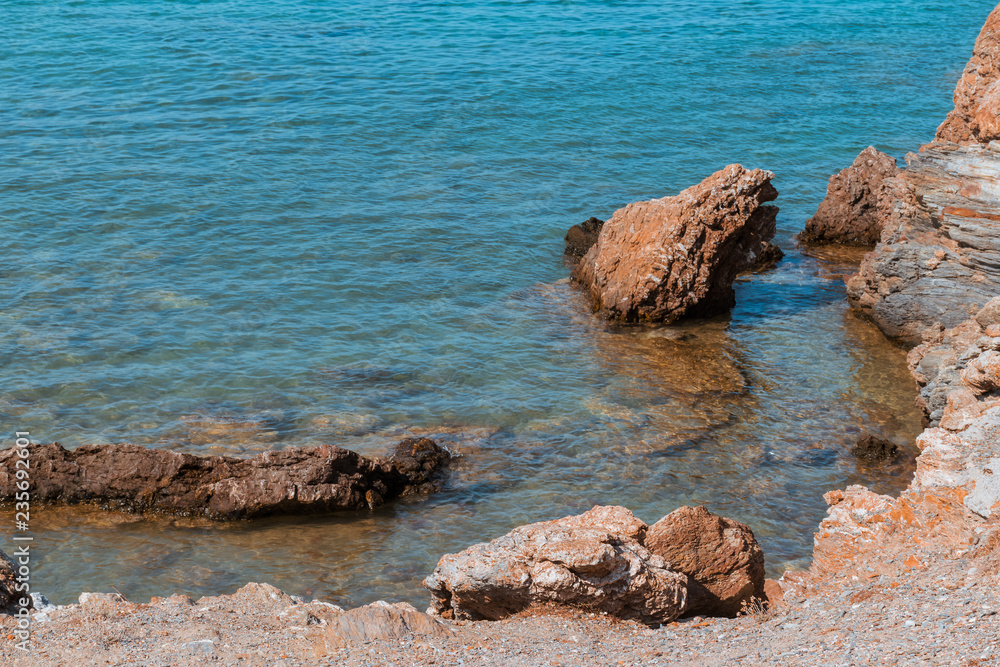 Rocky seashore in Greece - still transparent water of Aegean sea, copy space. Rocky seashore in Greece - still transparent water of Aegean sea, copy space.
