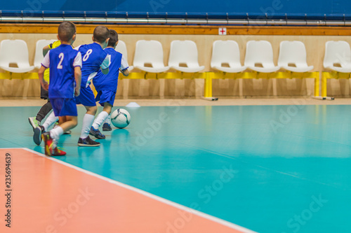 Принти на полотні kids in blue teams train and play football in the hall