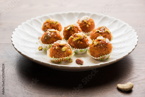 Carrot Halwa Laddu or sweet balls, served in a plate with dry fruits toppings. selective focus