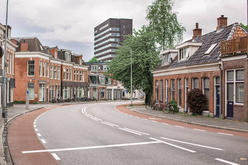 Typical street of the Dutch buildings and bicycles. Local architecture in Groningen, The Netherlands.