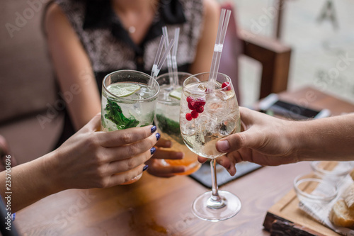 Group of friends having fun and drink cocktails. Cheers glasses in the hands. Summer mood in Minsk, Belarus.vk