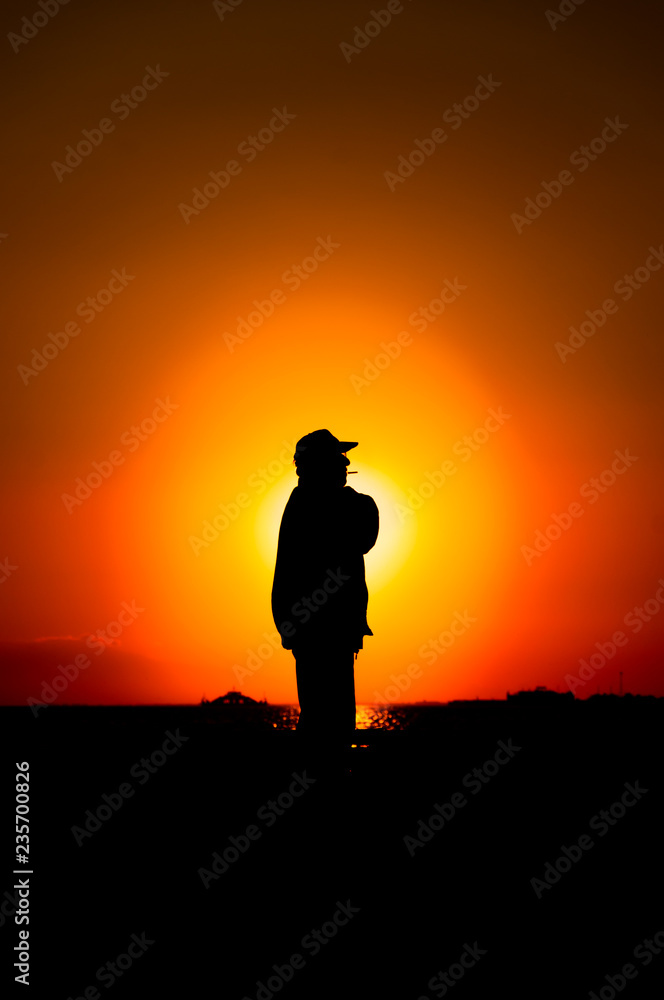 The silhouette old man at sunset. Seaside in Izmir, Turkey.