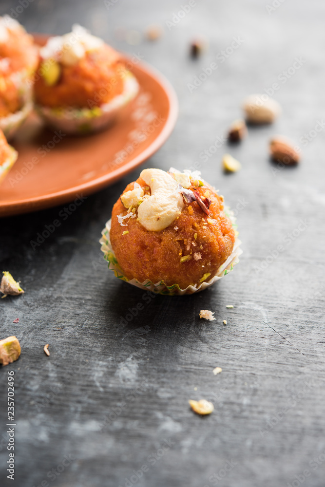 Fototapeta premium Carrot Halwa Laddu or sweet balls, served in a plate with dry fruits toppings. selective focus