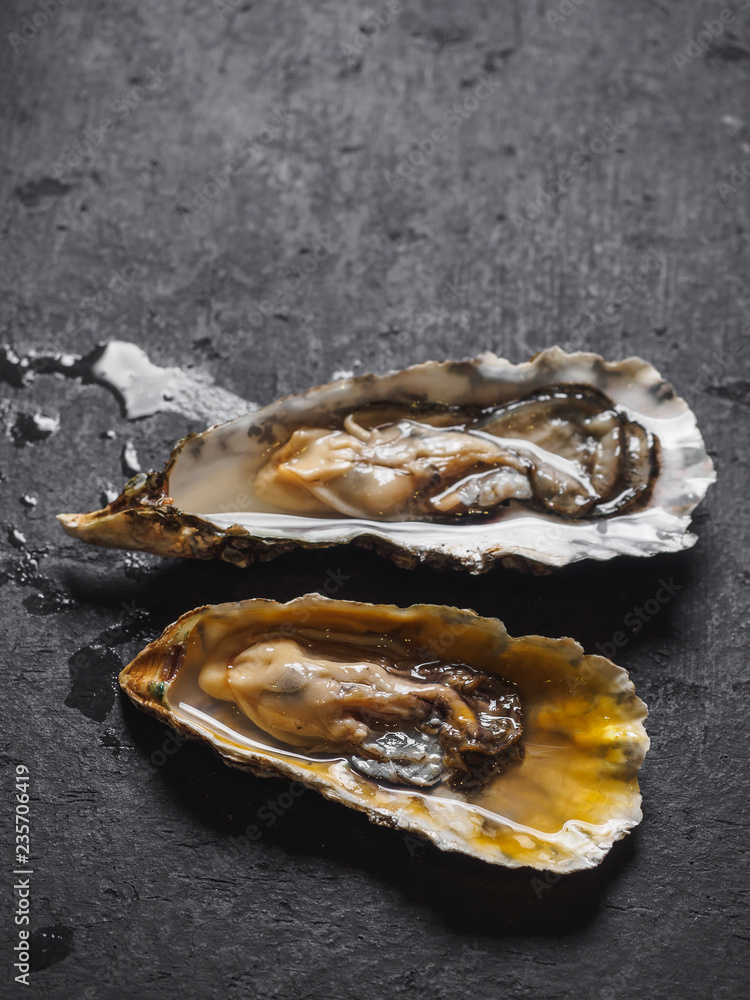 Raw oysters in shells on the black table Raw oysters in shells on the black table