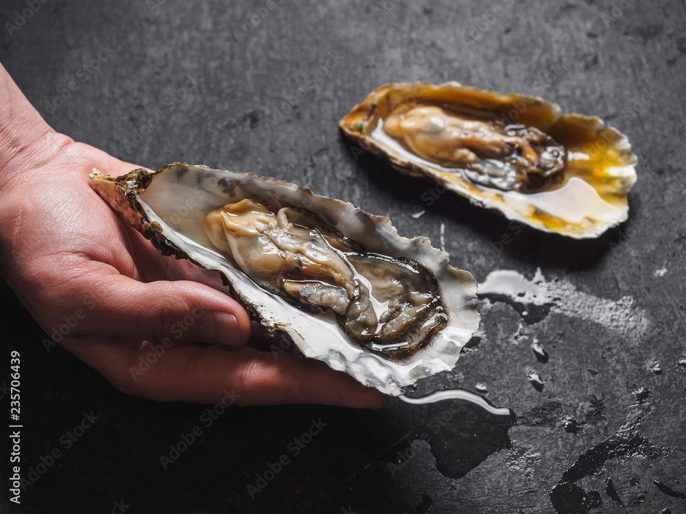 Raw oysters in shells on the black table Raw oysters in shells on the black table