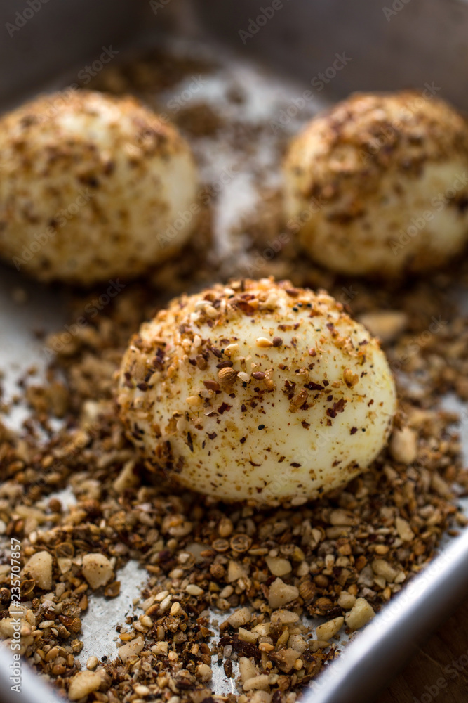Close up of eggs coated with spices in baking tray Close up of eggs coated with spices in baking tray