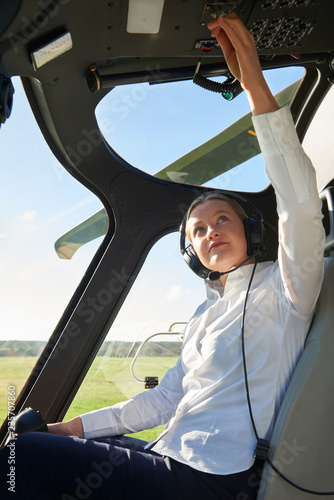 Female Pilot In Cockpit Of Helicopter Before Take Off