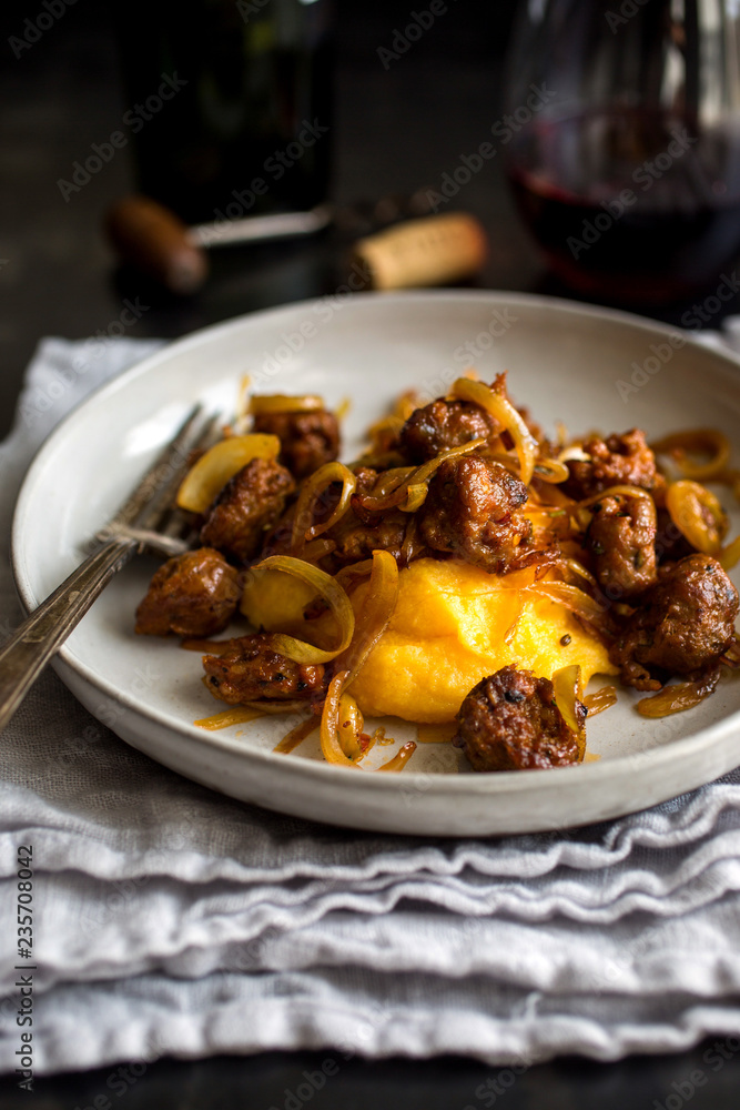 Close up of squash polenta with sausage and onion served on plate Close up of squash polenta with sausage and onion served on plate