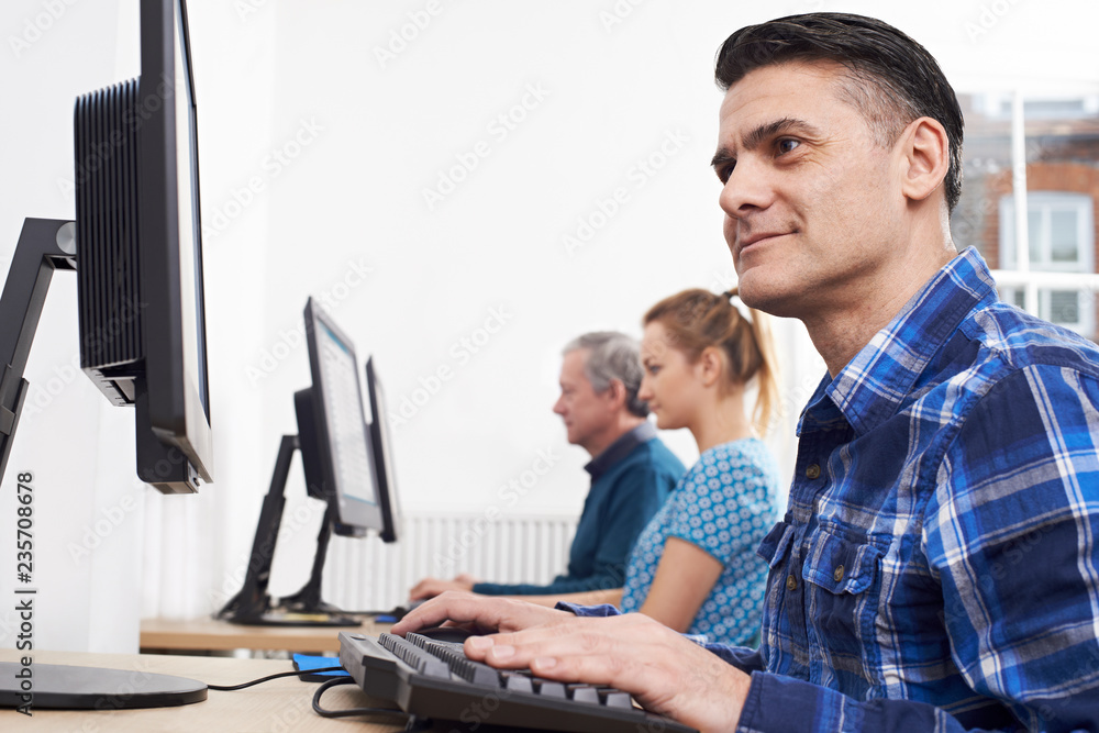 Mature Man Attending Computer Class In Front Of Screen