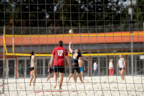 Group of young friends playing beach volleyball, summer day, selectiv focus. Blurred background, healthy lifestyle concept