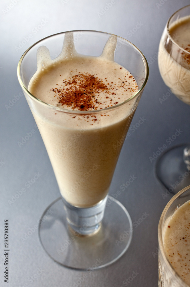 Close up of butterscotch scotch eggnog served in glass against gray background Close up of butterscotch scotch eggnog served in glass against gray background
