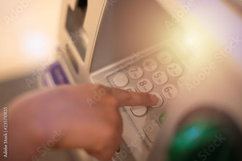 Woman is close up of hand, finger pressing keystroke cash machine, ATM banking Located in front of the bank. photo