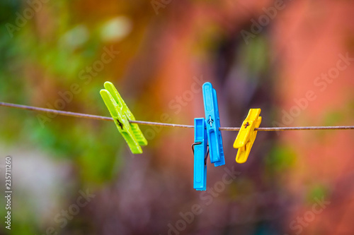 Colored plastic clothesline laundry clips hanging on rope