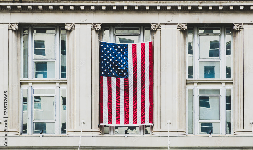 Washington DC, exterior view of a neoclassical government building with the flag of the United States of America
