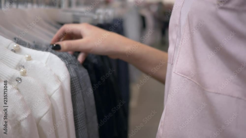 shopping time, customers girl select new stylish clothes on hangers in fashion shop during sales season, hands close up on unfocused background shopping time, customers girl select new stylish clothes on hangers in fashion shop during sales season, hands close up on unfocused background