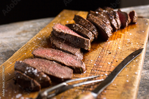 Close up of marinated sliced venison steaks on chopping board photo