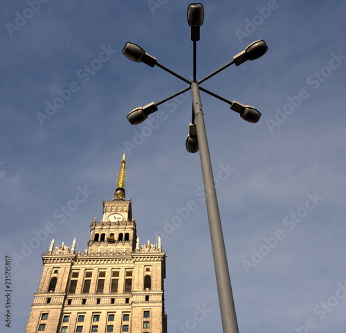 Spitze des Kultur- und Wissenschaftspalast vor strahlend blauem Himmel und Straßenlaterne im Vordergrund photo