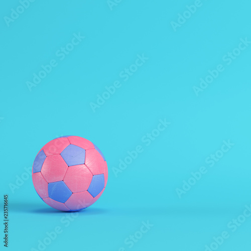 Pink soccer ball on bright blue background in pastel colors