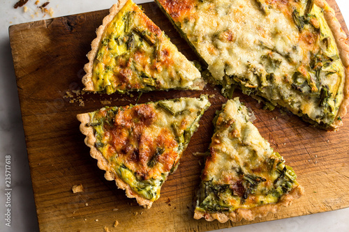 Close up of roasted asparagus and scallion quiche slices on cutting board