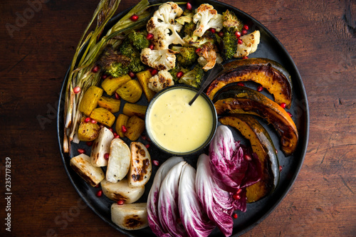 Overhead view of roasted autumn vegetables with aioli sauce photo
