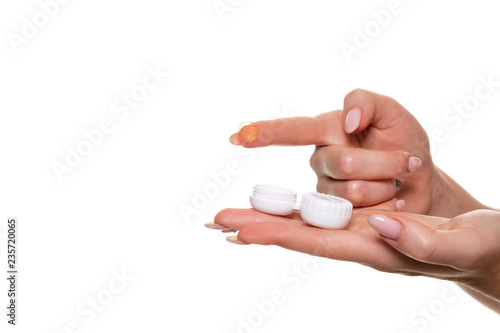 Contact eye lens. Close-up of woman hands holding white eyelense container.