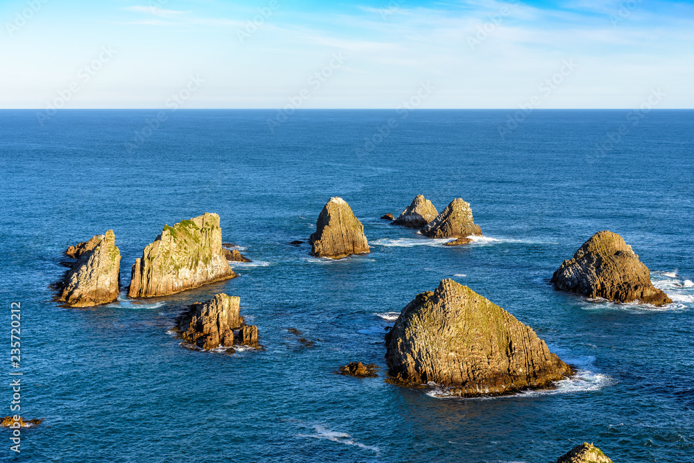 Stunning landscape at Nugget Point, one of the most distinctive spots on the Otago coast of New Zealand. It features a steep headland with a lighthouse and a dozens of rocky islets.