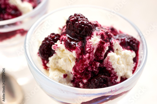 Close up of blackberry compote on ricotta served in glass