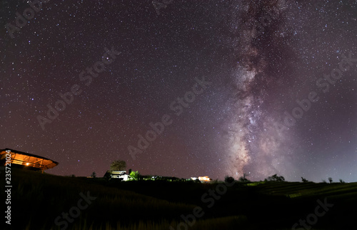 Milky Way Galaxy over hut on paddy rice field at night sky.