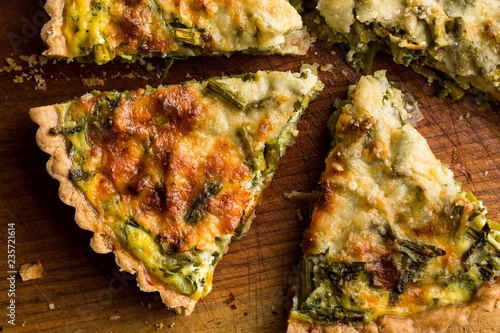 Close up of roasted asparagus and scallion quiche slices on cutting board