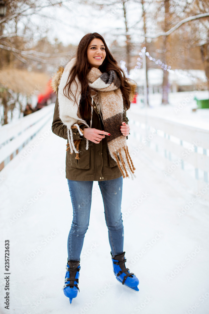 Young woman rides ice skates in the park Young woman rides ice skates in the park