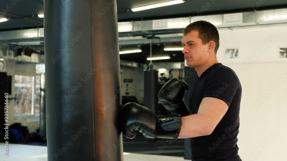 MMA fighter Boxers doing some training on a punching bag at a gym close up power punch kicks macro MMA fighter Boxers doing some training on a punching bag at a gym close up power punch kicks macro