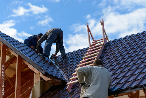 Masters make the roof of the frame house, metal on the roof of a new house