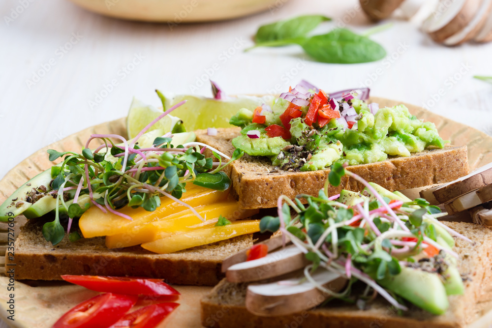 Selection of avocado toasts on grain bread. Healthy plant-based food Selection of avocado toasts on grain bread. Healthy plant-based food