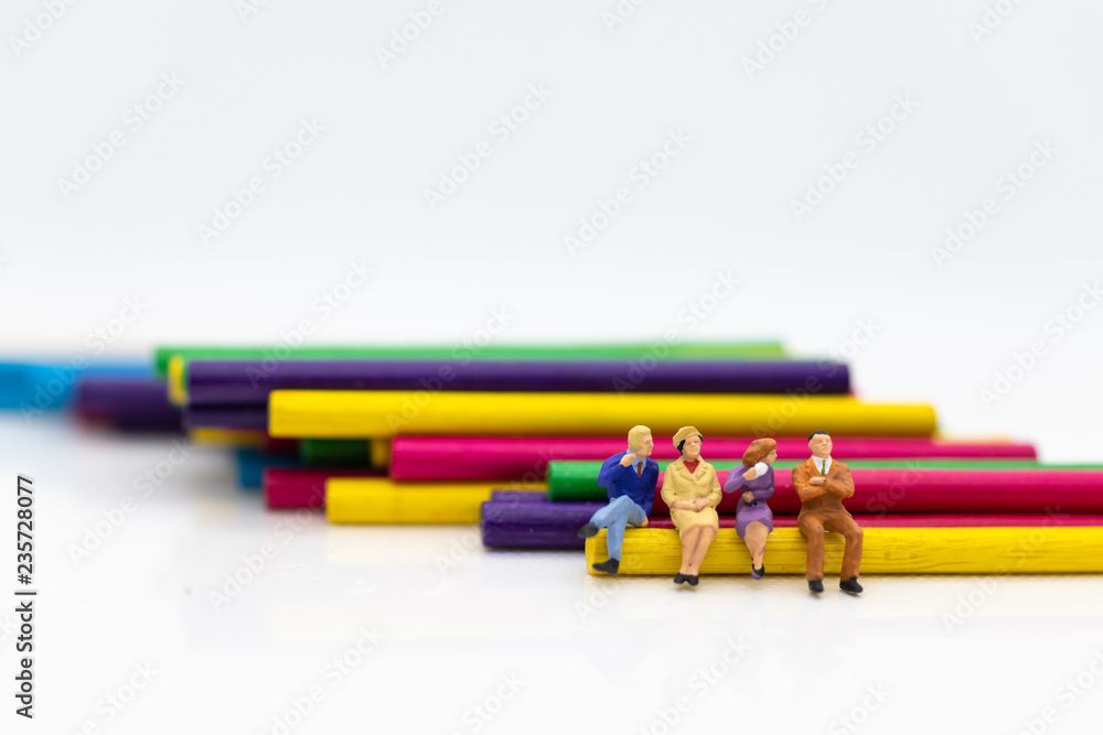 Miniature people: Businessmen sitting on colorful wood sticks. Image use for a variety of ideas, business team concept. Miniature people: Businessmen sitting on colorful wood sticks. Image use for a variety of ideas, business team concept.