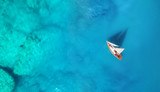 Yacht on the water surface from top view. Turquoise water background from top view. Summer seascape from air. Travel concept and idea