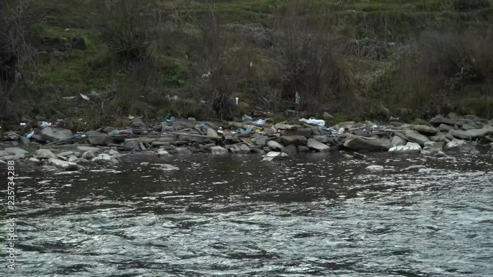 Rubbish on the river. Garbage in a mountain river. Environmental pollution. Pollution of nature. Ecological catastrophy. Non-degradable plastic. Rubbish on the river. Garbage in a mountain river. Environmental pollution. Pollution of nature. Ecological catastrophy. Non-degradable plastic.
