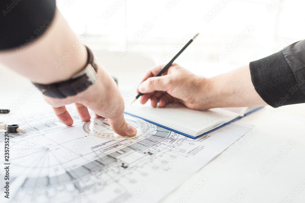 architect builder works at the table with drawings. Helmet, drawings, compasses in the workplace architect builder works at the table with drawings. Helmet, drawings, compasses in the workplace